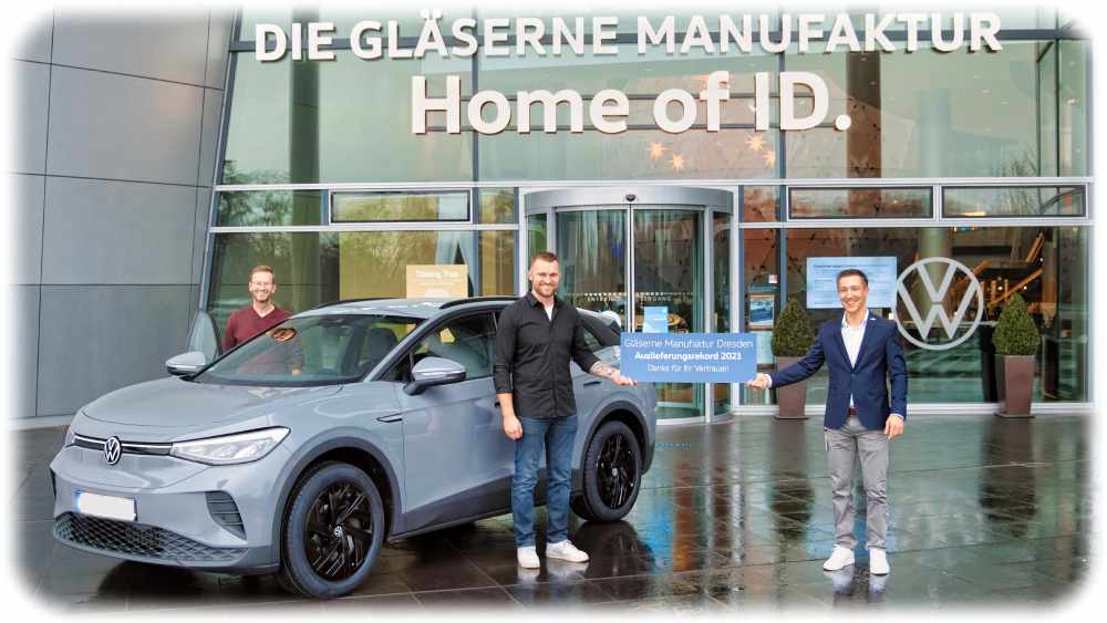 Stefan Beer (Mitte) ist mit seinem Schwiegervater aus Bayern angereist, um in der Volkswagen-Manufaktur Dresden seinen neuen ID4 abzuholen. Rechts daneben steht VW-Mitarbeiter Robert Pardavi. Foto: VW Sachsen