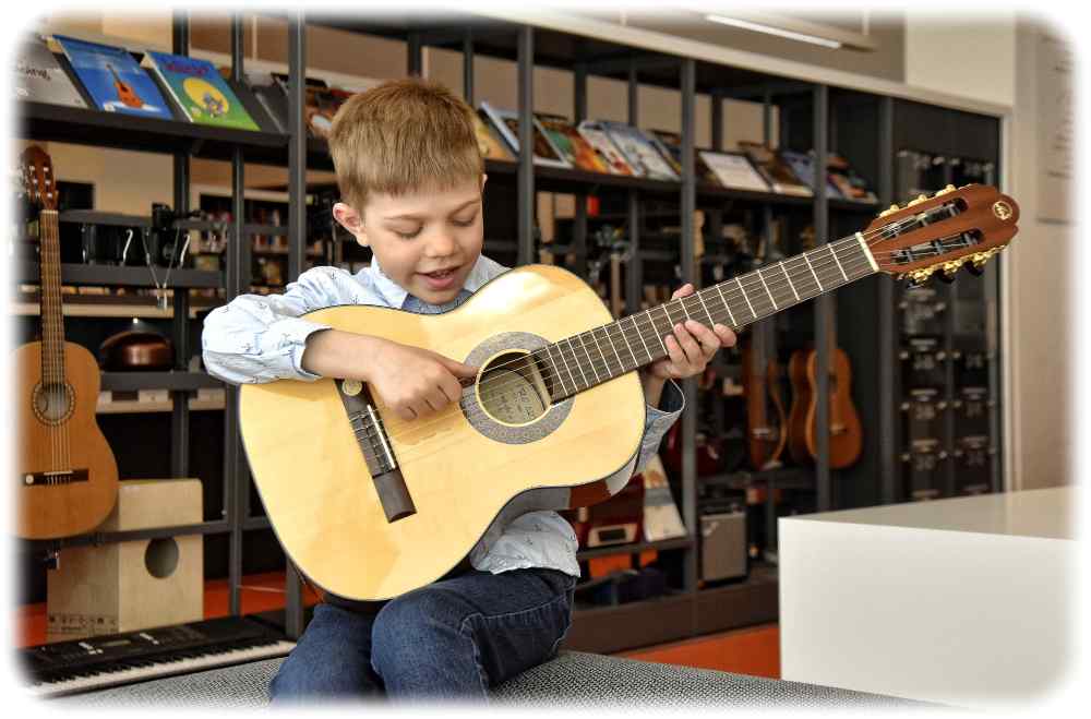 Der siebenjährige Julius Jockwitz hat sich aus der "Bibliothek der Dinge" in Dresden eine Gitarre geliehen. Foto: Städtische Bibliotheken Dresden