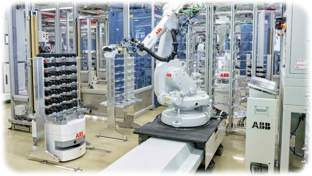 Ein Industrieroboter be- und entlädt in einer Halbleiterfabrik im Schweizerischen Lenzburg einen mobilen Roboter "BlueBotics mini" von ABB. Foto: ABB / IFR