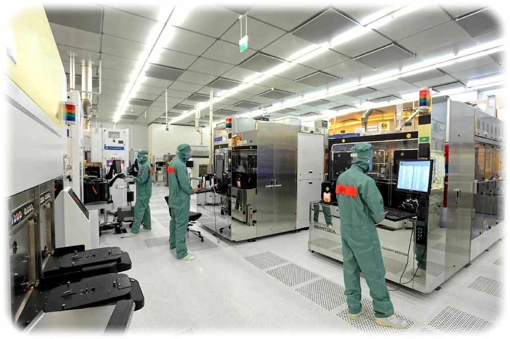 Ingenieure bedienen in einem Reinraum des Fraunhofer-Photonikinstituts IPMS in Dresden Anlagen für die experimentelle Chipfertigung. Foto: Max Drescher für das Fraunhofer-IPMS