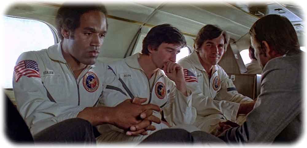 Die verhinderten Mars-Astronauten John Walker (O. J. Simpson), Peter Willis (Sam Waterston) und Charles Brubaker (James Brolin, v.l.n.r.) ärgern sich, dass sie aus der Rakete rausgezerrt worden sind. Abb.: Koch, aus: Unternehmen Capricorn
