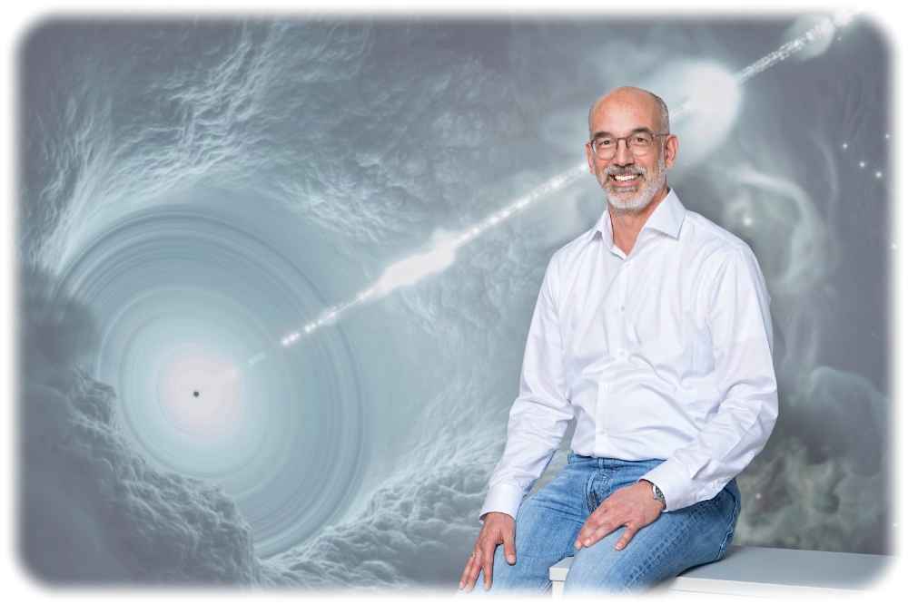 Prof. Christian Stegmann vom Forschungszentrum Dasy gehört zu den geistigen Vätern des "Deutschen Zentrums für Astrophysik" (DZA), das in der Lausitz entstehen soll. Hier sitzt er neben der künstlerischen Darstellung eines kosmischen Teilchenbeschleunigers, eines Blasars. Foto: G. Born für das Desy