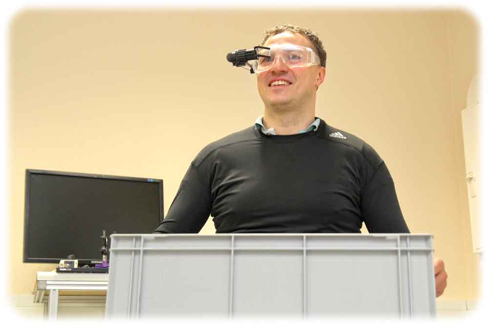 Prof. Rigo Herold führt den Sensoranzug mit Datenbrille vor. Transportarbeiter können durch Sensoren und Brille beispielsweise Warnungen bekomen, wenn sie zu schwere Kisten tragen und verkrampfen. Foto: WHZ