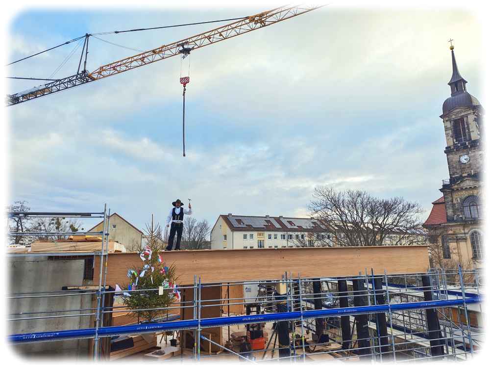 Der Polier schwingt den Hammer: Der Rohbau für die DIS-Erweiterung steht. Foto: Heiko Weckbrodt