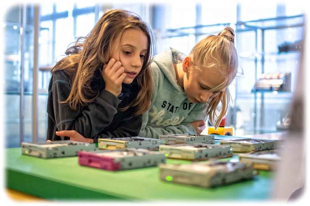 Zwei junge Besucherinnen schauen sich beim Medienfestival in Dresden eine Floppy-Installation an. Foto: Steffen Haas