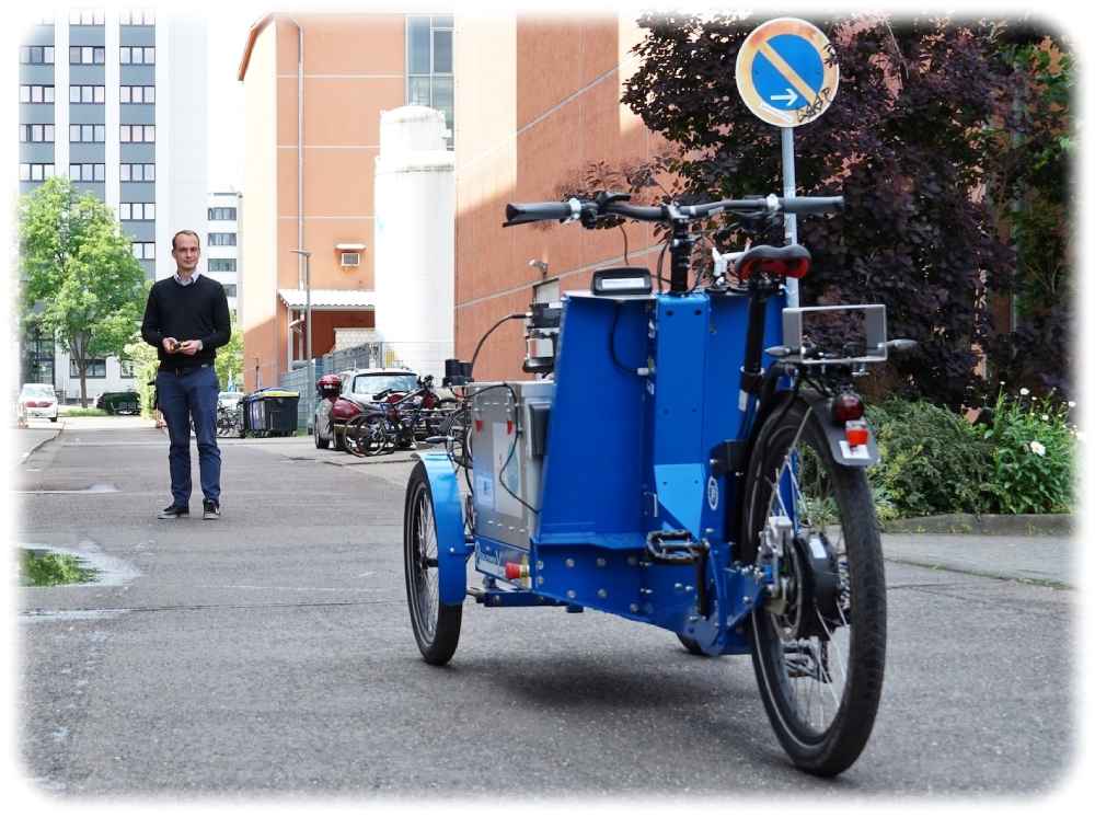 Geht der Trend zum automatischen Lastenrad? Auf diesem Bild der Uni Magdeburg ruft Tom Assmann ein autonomes Lastenrad zu sich. Foto: Markus Höfer für die Uni Magdeburg