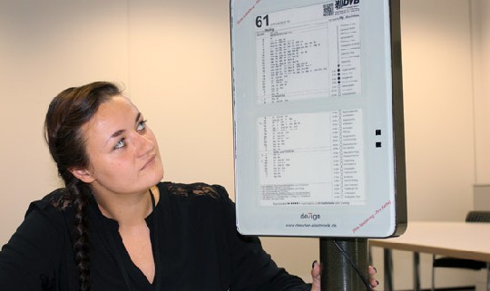 Technikassistentin Franziska Jahn zeigt einen der neuen Fahrplanaushänge mit elektronischem Papier von Plastic Logic. Foto: Heiko Weckbrodt