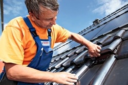 Dachdecker Uwe Spindler passt das schwarze Solardach ein. Abb.: Solarwatt
