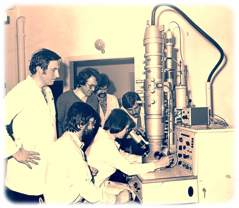 Akademiker-Alltagsfreuden in der DDR: Das Kollektiv hat ein eigenes Elektronen-Mikroskop! Autor Gerhard Barkleit ist auf dieser Aufnahme in der Mitte im Pullover zu sehen. Foto (bearbeitet): Dr. Gabriele Barkleit