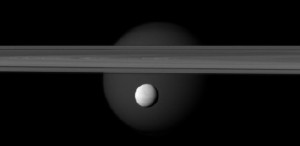 Cassini-Foto: Saturn-Eismond Enceladus (klein vorn) unter den Saturnringen, im Hintergrund Titan. Abb.: NASA, ESA