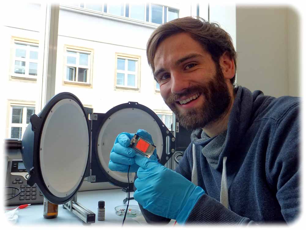 Felix Simon Fries zeigt eine Organische Leuchtdiode (OLED), die in der neuen Architektur angefertigt wurde. Foto: IAPP
