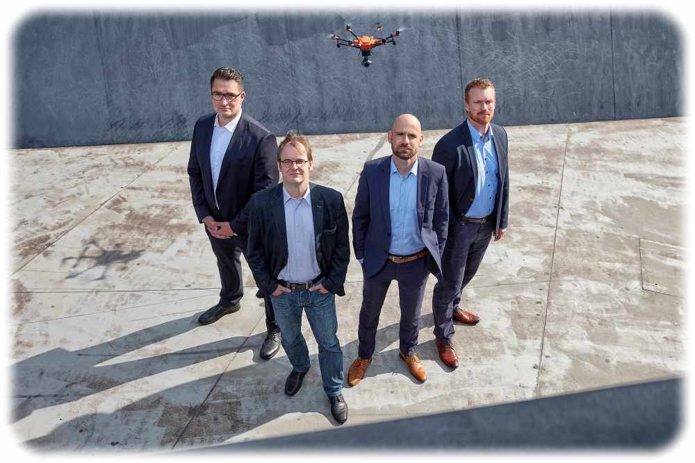 Die Flynex-Gründer betrachten ernst eine fliegende Drohne. Foto: Flynex