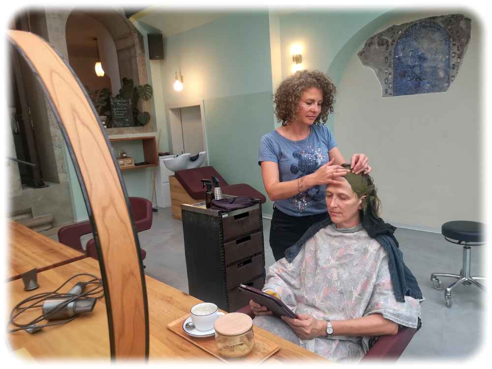 Frisörin Angela Mießner kümmert sich im Salon Beke um die Haare einer Kundin, die derweil Zeitschriften auf dem Tablet lesen kann. Foto: Heiko Weckbrodt