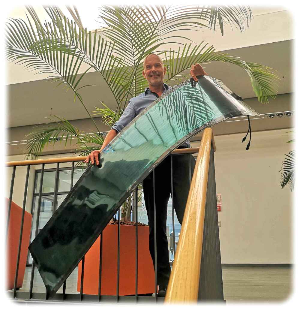 Heliatek-Chef Guido van Tartwijk zeigt ein zwei Meter langes und biegsames organisches Solarmodul aus Dresdner Produktion. Foto: Heiko Weckbrodt
