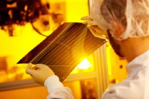 Ein Heliatek-Mitarbeiter prüft in der Dresdner Fabrik ein organisches Solarmodul. Seit zwei Wochen spuckt die Anlage funktionsfähige Muster aus, in zwei Monaten sollen verkaufsfähige Produkte bereit stehen. Abb.: Heliatek