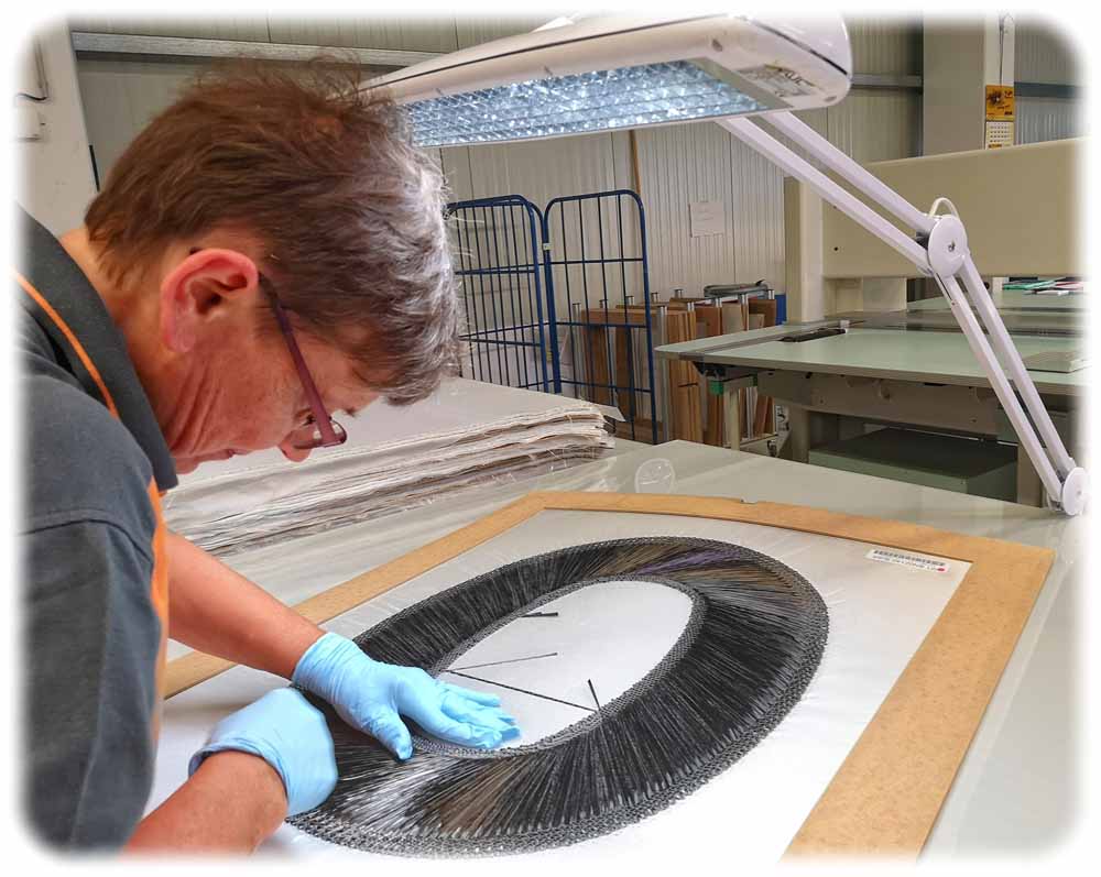 Zuarbeiterin Heike Meier kontrolliert bei Hightex Klipphausen die maschinengelegten Karbonfasern für Flugzeug-Fensterrahmen auf fehlerhafte Spalten. Foto: Heiko Weckbrodt