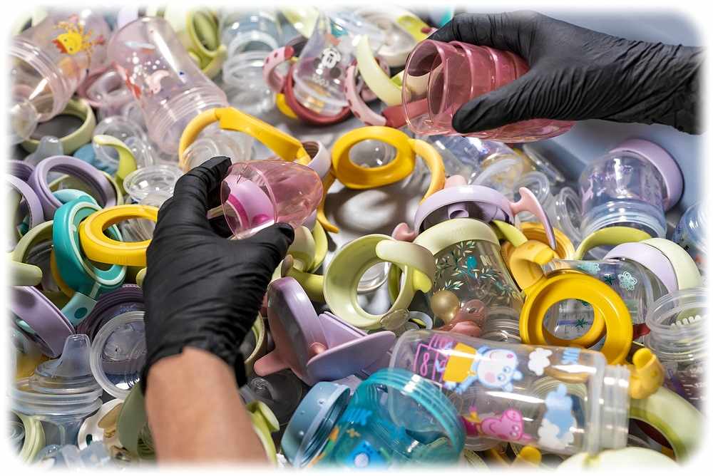 Ein Holypoly-Mitarbeiter sortiert ausgemusterte Kinder-Trinkflaschen von Nuk. Foto: Holypoly