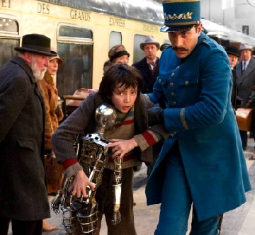 Köstlich: Sacha Baron Cohen als pedantischer Stationsvorsteher, der hier Hugo und seinen mechanischen Freund durch den Bahnhof zerrt. Abb.: Paramount