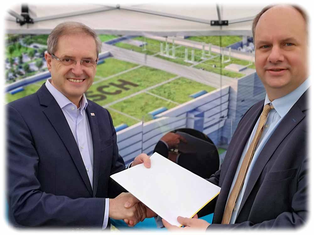 Oberbürgermeister Dirk Hilbert (rechts) übergibt Werkleiter Otto Graf dioe Genehmigung für den Innenausbau der Bosch-Chipfabrik in Dresden. Foto: Heiko Weckbrodt