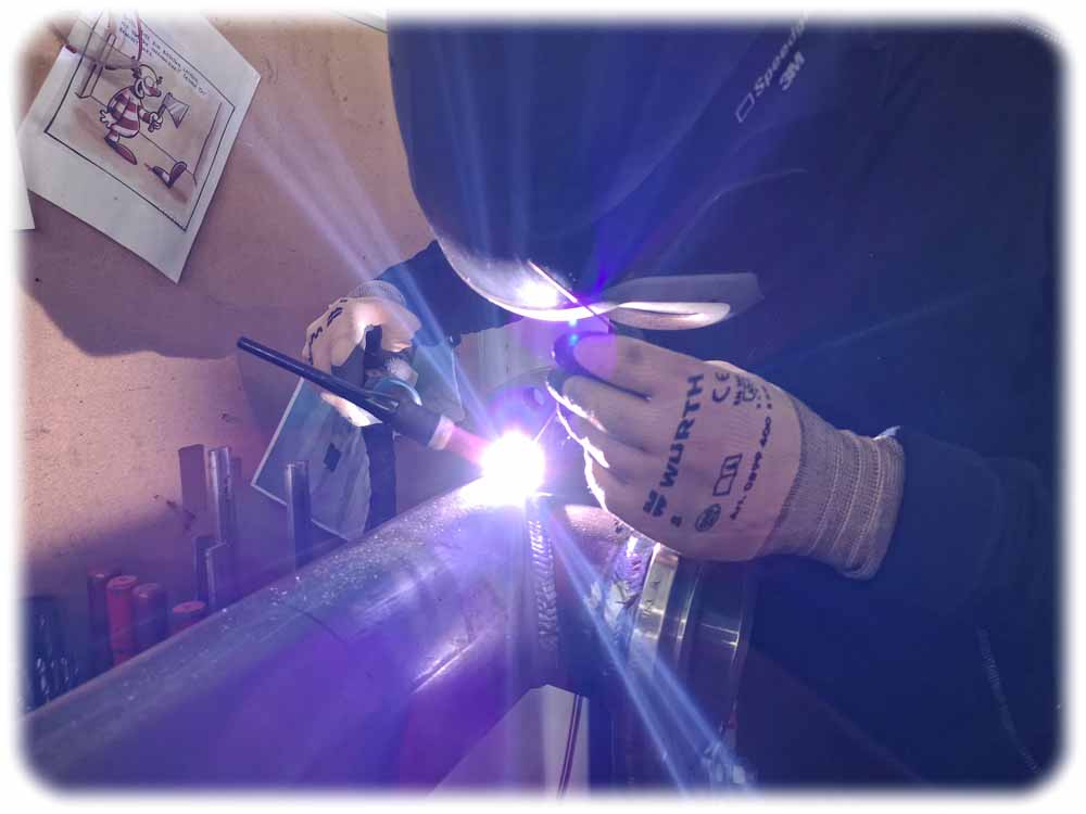 Biofabrik-Mechaniker Tony Haupt schweißt am Rohr einer Pyrolyse-Anlage eine Halterung für ein Keramik-Bauelement an. Foto: Heiko Weckbrodt
