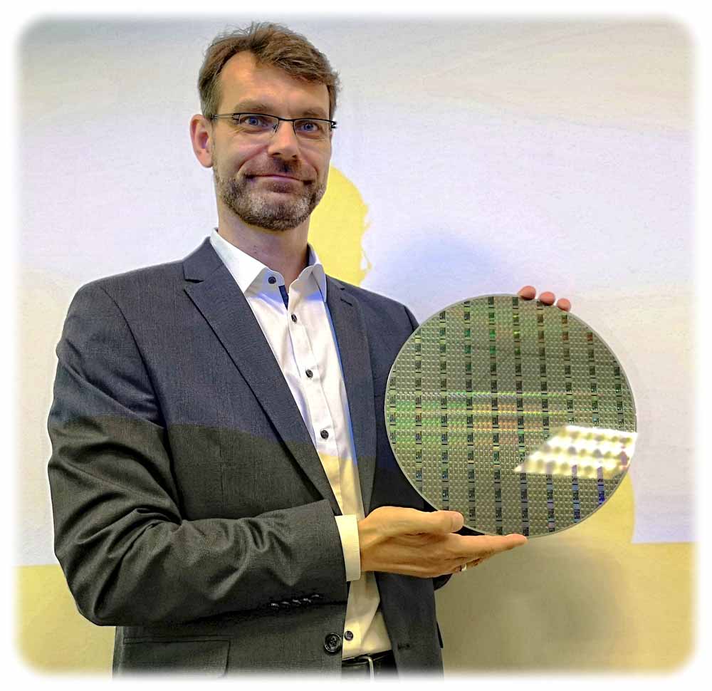Oliver Aubel ist in der Globalfoundries-Fabrik Dresden für das Automobil-Chipprogramm zuständig. Hier zeigt er einen Wafer mit Chips für die Autoindustrie. Foto: Heiko Weckbrodt