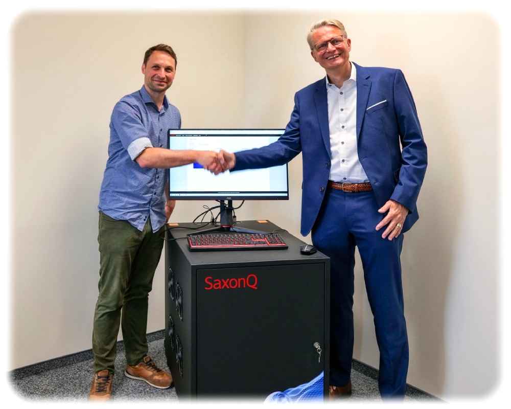 Prof. Marius Grundmann (rechts) von "SaxonQ" übergibt den Quantencomputer an IWU-Ingenieur Albrecht Hänel, der für "Digoitale Zwillinge" zuständig ist. Foto: Fraunhofer-IWU