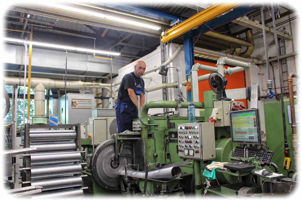 Ein Mitarbeiter richtet in der "federal Mogul"-Fabrik Dresden eine Schleifmaschine für Kolbenringe ein. Foto: Heiko Weckbrodt