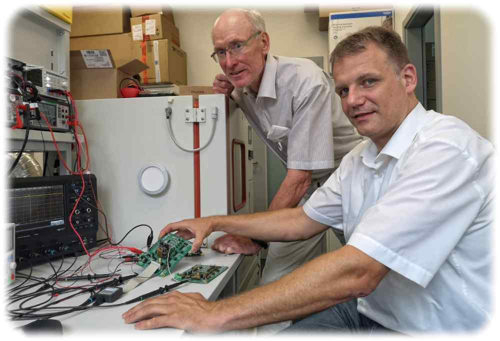 Ingenieur Karsten Neumann (rechts) und Indie-Deutschlandchef Klaus Hermann inspizieren an einem Messplatz in ihrem Labor im Robolab eine Platine für einen neue entworfenen Autochip. Foto: Heiko Weckbrodt
