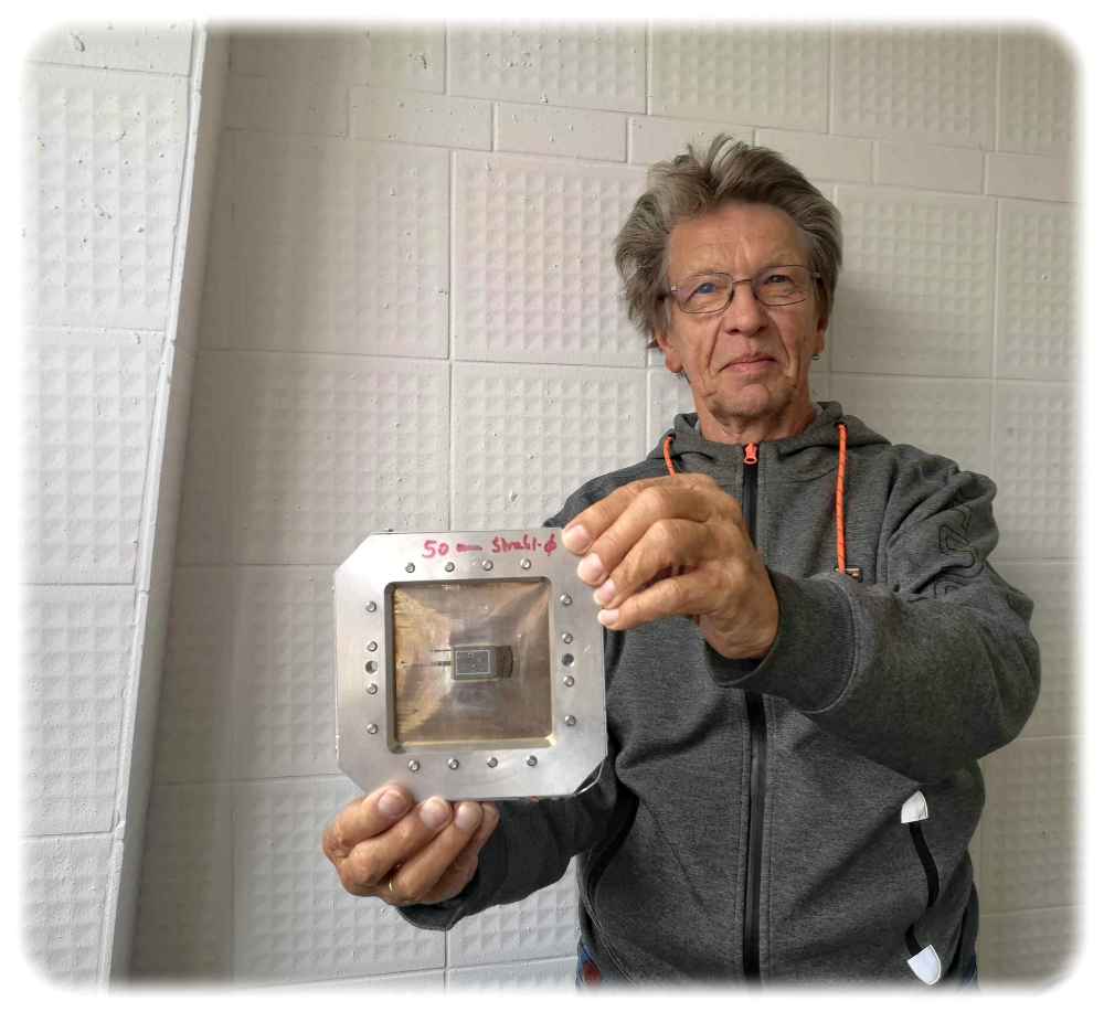 Der Dresdner Physiker Andreas Steinbrecher war ab 1978/79 an dem Projekt Ionenprojektor im Institut für Mikroelektronik Dresden (IMD) beteiligt. Hier im Foto aus dem Jahr 2023 zeigt er in den Technischen Sammlungen eine der damals verwendeten Masken. Foto: Heiko Weckbrodt 