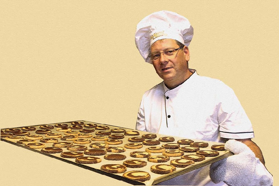 Bäckermeister Matthias Walther bereitet in seiner Backstube ein Keksblech vor. Foto: Heiko Weckbrodt