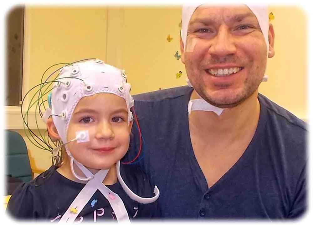 Die Wissenschaftler untersuchten mithilfe des EEG (im Bild: weiße Kappe) die Hirnströme der Kinder mit Cochlea-Implantaten (im Bild links in türkis) während sie neue Wörter lernten. Foto: Niki Vavatzanidis, MPI CBS