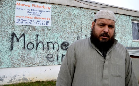 Saad Elgazar, der Vorsitzende der muslimischen Gemeinde, vor der beschmierten Wand. Foto: Stephan Hönigschmid