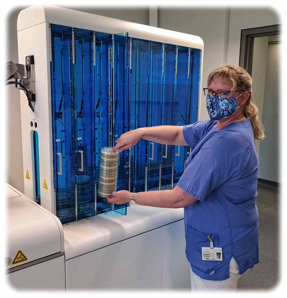 Die medizintechnische Assistentin Susanne Schubert entlädt fertig bestrichene Petrischalen aus dem neuen Laborautomaten in der Mikrobiologie im Uniklinikum Dresden. Foto: Heiko Weckbrodt