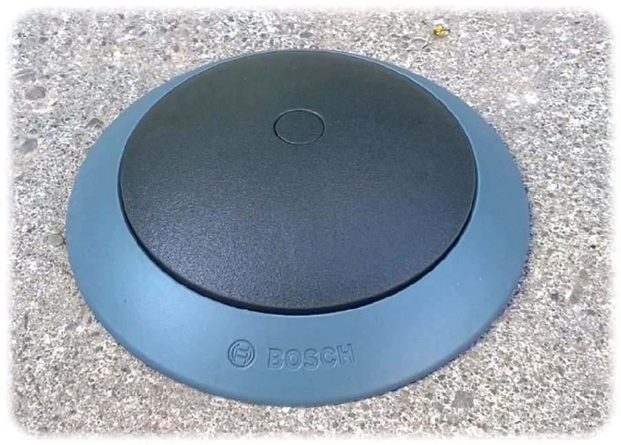 Bosch setzt auf flache runde Sensoren, die direkt auf die Fahrbahn gesetzt werden, um intelligente Parkplatz-Suchsysteme zu ermöglichen. Foto: Bosch
