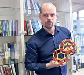Prof. Jeroen van den Brink mit einem Modell der Moleküle. Foto: IFW