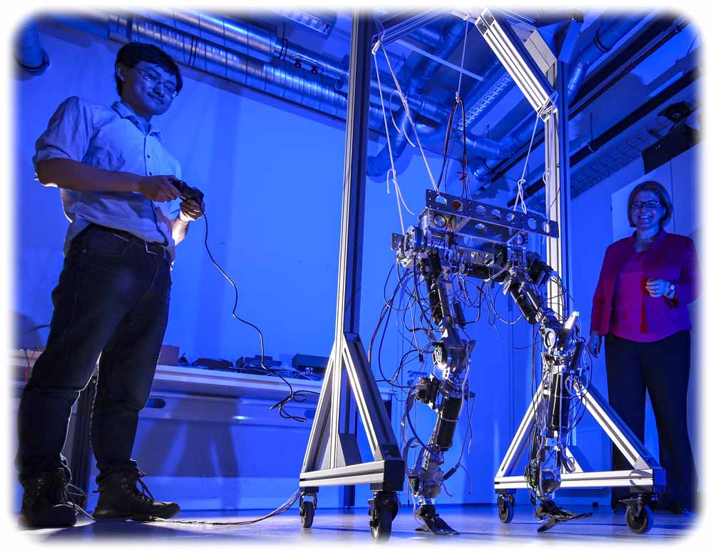 Doktorand Hongxi Zhu und Professorin Ulrike Thomas probieren gemeinsam den Laufroboter aus, in dem das nachgiebige Robotergelenk integriert werden kann, Foto Jacob Müller für die TU Chemnitz