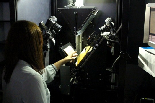 Annekathrin Weser betreut im SLUB-Digitalisierungszentrum einen Scan-Roboter für die Massen-Digitalisierung, der etwa 500 Buchseiten pro Stunde schafft. Foto: Heiko Weckbrodt