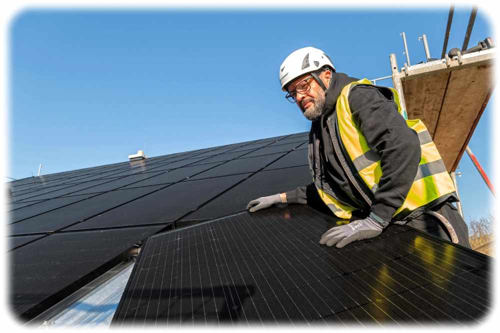 Ein Solarwatt-Installateur fixiert Photovoltaik-Module auf einem Dach. Foto: Solarwatt