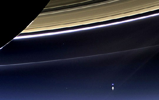 Die über 12.000 km große Erde erscheint vom Saturn aus wie ein wenizige fahlblauer Punkt (siehe Pfeil). Foto: NASA