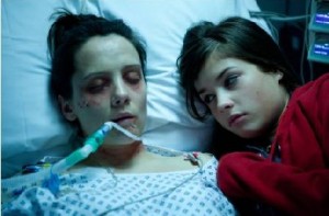 Kayla (r.) neben ihrer zusammengeschlagenen Schwester auf dem Krankenbett. Abb.: Sunfilm