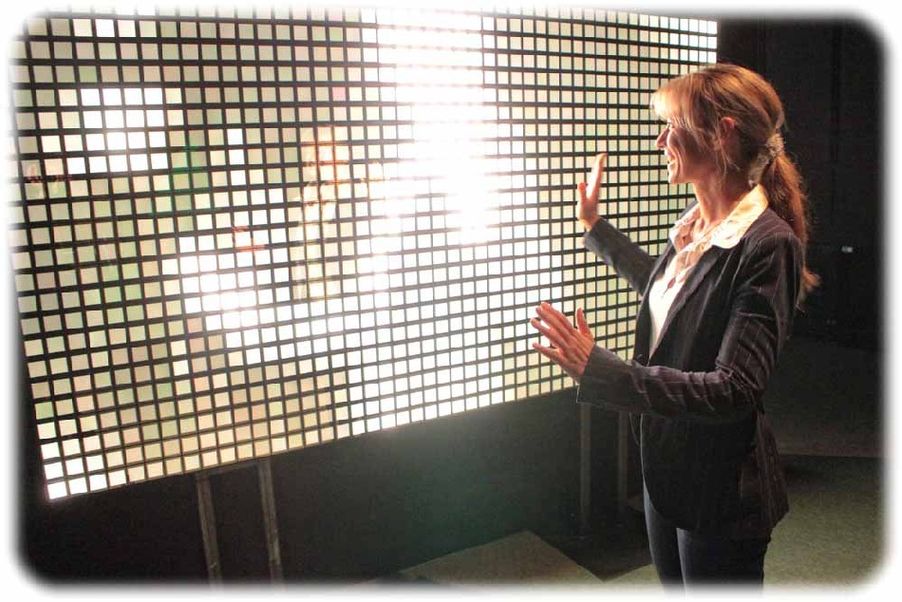 Anke Lemke von der Dresdner OLED-Firma Novaled probiert die sehende Organikleuchtwand in den Technischen Sammlungen Dresden aus: Lichtsensoren erfassen ihre Bewegungen und übersetzen sie in die leuchtenden Quadratkonturen der Organikkacheln. Foto: Heiko Weckbrodt