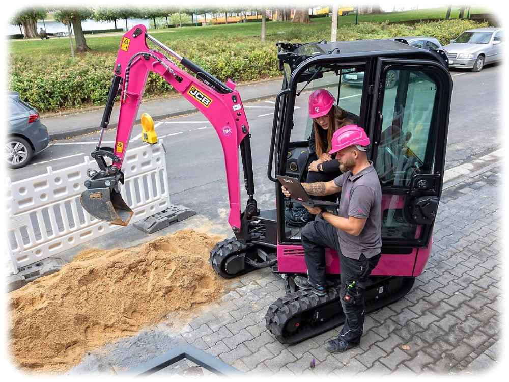 Marie-Christine Berger und Sascha Balthun von der "Telekom Technik" freuen sich über die rosa Bagger. Foto: Deutsche Telekom