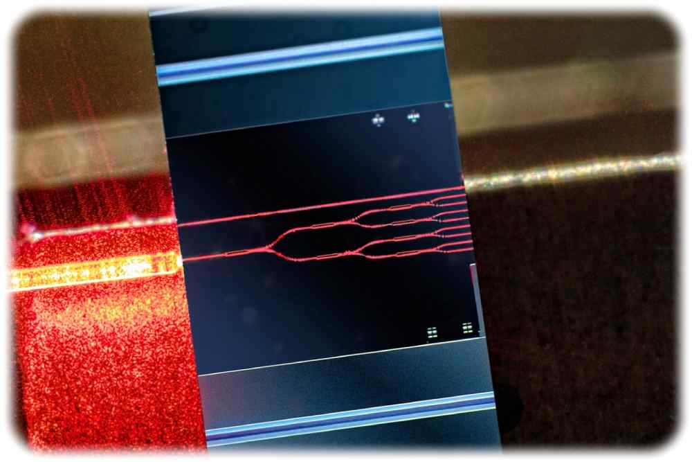 Ein Testmuster mit einer durch rotes Licht gefluteten photonischen Schaltung. Foto: Fraunhofer-IZM