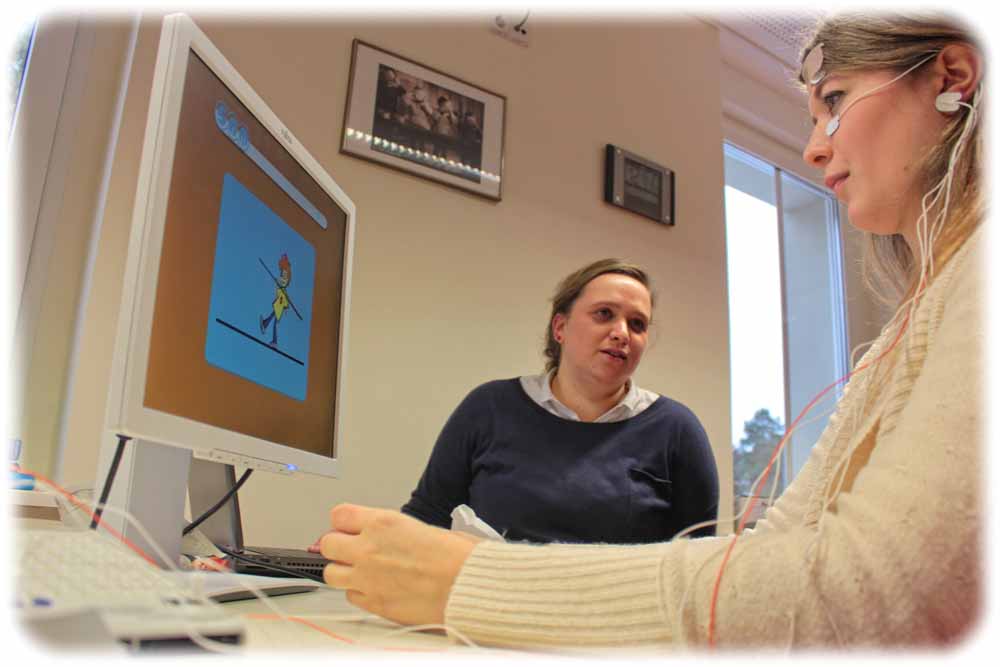 Praktikantin Sophie Schwab (rechts) und Dr. Annet Bluschke demonstrieren, wie ADHS-Kinder mit Gedankenkraft Videospiele steuern und dadurch Kontrolle trainieren. Foto: Heiko Weckbrodt