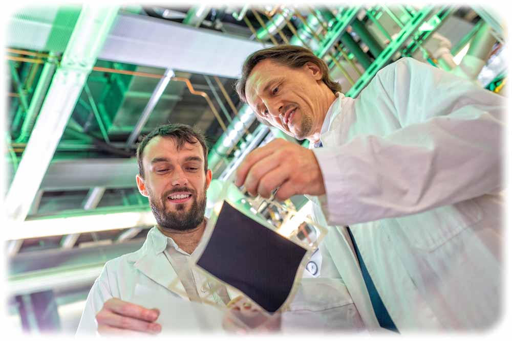 Prof. Dr. Thomas von Unwerth (r.) und Laborleiter Vladimir Buday inspizieren im Brennstoffzellenlabor an der TU Chemnitz eine additiv produzierte Membran. Foto: Ronald Bartel für die TUC