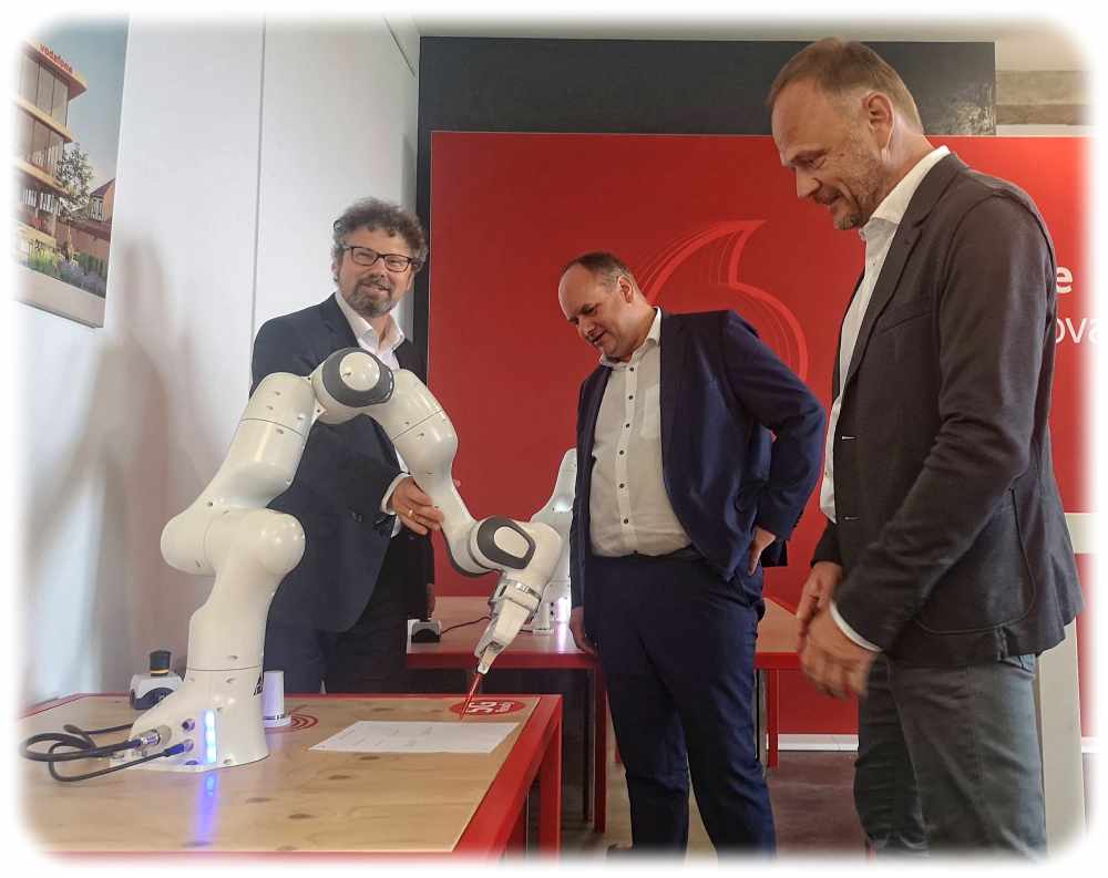 Voadone-Innovationsarchitekt Ralf Irmer (links) zeigt Oberbürgermeister Dirk Hilbert (Mitte) und Investor Thomas Bohn (rechts) einen Roboter, der die Verträge fürs neue Vodafone-Entwicklungszentrum Dresden unterschreiben kann. Foto: Heiko Weckbrodt