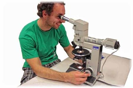 Ein Besucher schaut durch ein Polarisations-Mikroskop des Helmholtz-Zentrums Dresden-Rossendorf, mit dem Minerale farbanalyisieren kann. Foto: hw