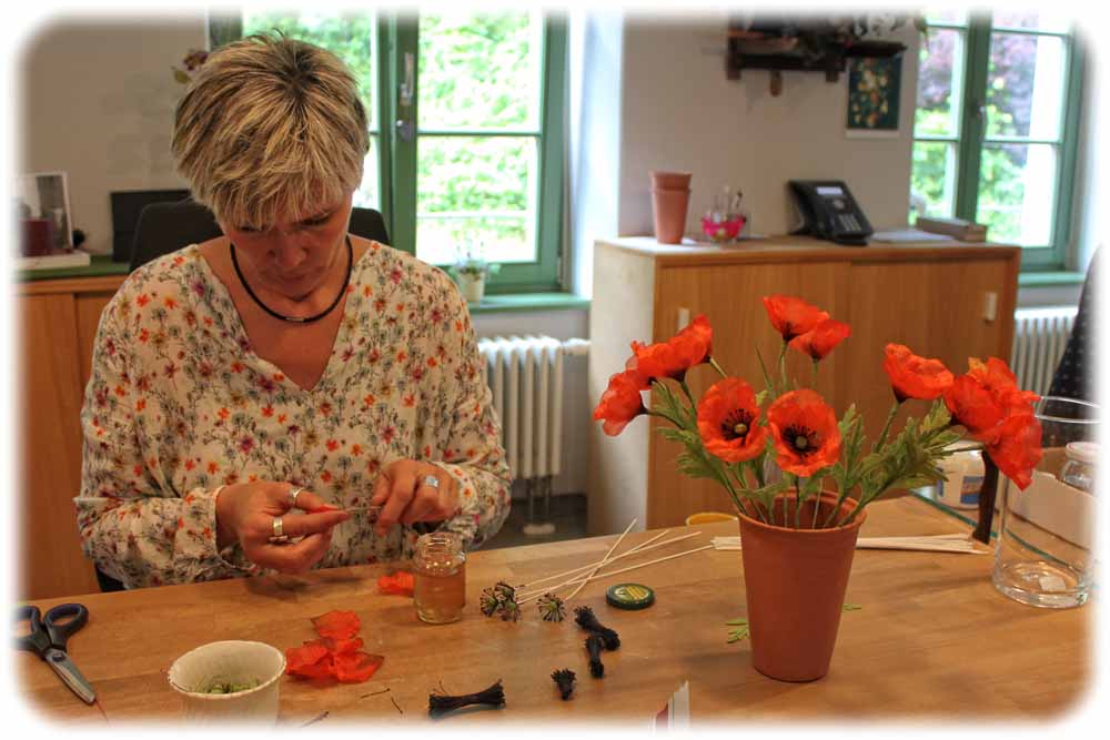 Manufakturmitarbeiterin Heike Kühnel bei der Anfertigung von seidenen Mohnblumen. Foto: Peter Weckbrodt