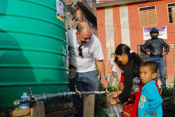  Projektleiter Friedrich Machein von arche noVa hilft bei der Wasserverteilung in der Erdbeben-Region in Bhaktapur. Foto: arche NoVa