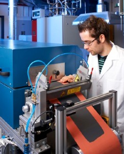 Ein Fraunhofer-Mitarbeiter besichtet im Rolle-zu-Rolle-Verfahren elektroden für Lithium-Schwefel-Akkus. Foto: Jürgen Jeibmann/ Fraunhofer IWS